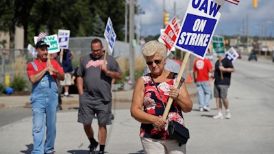 Mara Paulic, a 42-year GM employee, pickets outside the General Motors Fabrication Division, Monday, Sept. 23, 2019, in Parma, Ohio.
