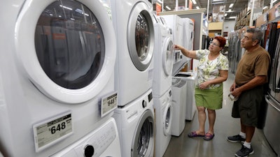 In this Sept. 23, 2019, photo, Maria Alvarez and her husband Guillermo Alvarez examine washers and dryers at a Home Depot location in Boston.