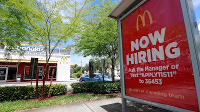 In this Monday, July 1, 2019, file photo, a 'Now Hiring' sign appears on a bus stop in front of a McDonald's restaurant in Miami.