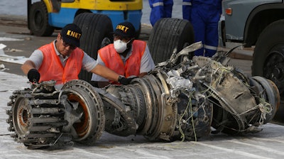 In this Nov. 4, 2018, file photo officials inspect an engine recovered the crashed Lion Air jet in Jakarta.