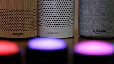 In this Sept. 27, 2017, file photo, Amazon Echo and Echo Plus devices, behind, sit near illuminated Echo Button devices during an event announcing several new Amazon products by the company in Seattle.