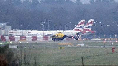 A police helicopter flies over Gatwick Airport after drones were spotted over the airfield, Dec. 20, 2018.