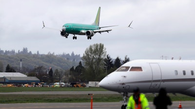 In this April 10, 2019, file photo a Boeing 737 MAX 8 airplane being built for India-based Jet Airways, top, lands following a test flight at Boeing Field in Seattle. Federal safety officials say Boeing should consider how cockpit confusion can slow the response of pilots who are dealing with the kind of problem that likely caused two airliners to crash in the past year.