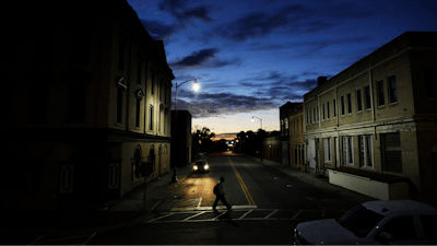 In this Oct. 28, 2017, file photo a pedestrian crosses a downtown street at dusk in Lumberton, N.C. Small and mid-sized businesses are having a harder time getting credit and that’s having an impact on their plans to hire. Those are findings of a quarterly survey of small businesses released Monday by Pepperdine University’s Graziadio School of Business and Management and Dun & Bradstreet Corp.