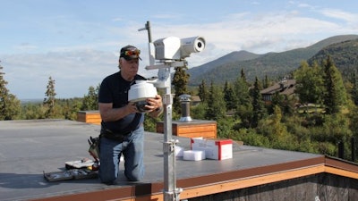 John Parker installs a new wildfire monitoring system on the roof of an Anchorage home. The Anchorage Fire Department hopes it will help them spot wildfires faster.
