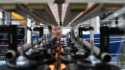 In this May 15, 2019, file photo, a factory worker checks parts at a manufacturing plant for automobile air conditioners in Yantai in eastern China's Shandong province. Two gauges of Chinese factory activity improved in September ahead of talks with Washington aimed at ending a tariff war, according to survey released Monday, Sept. 30, 2019.