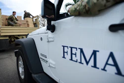In this Oct. 5, 2017 file photo, Department of Homeland Security personnel deliver supplies to Santa Ana community residents in the aftermath of Hurricane Maria in Guayama, Puerto Rico. Federal authorities said Tuesday, Sept. 10, 2019, that they have arrested two former officials of the Federal Emergency Management Authority and the former president of a major disaster relief contractor, accusing them of bribery and fraud in the efforts to restore electricity to Puerto Rico in the wake of Hurricane Maria.