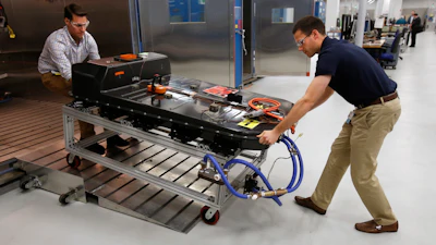 In this Nov. 4, 2016, file photo, a Chevrolet Bolt EV battery pack is removed for testing after undergoing charging and discharging cycles at General Motors Warren Technical Center's Advanced Energy Center in Warren, Mich. If U.S. consumers ever ditch fuel burners for electric vehicles, then the United Auto Workers union is in trouble. Gone would be thousands of jobs at engine and transmission plants across the industrial Midwest, replaced by smaller workforces at squeaky-clean mostly automated factories that mix up chemicals to make batteries.