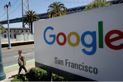 In this May 1, 2019, file photo a man walks past a Google sign outside with a span of the Bay Bridge at rear in San Francisco. A group of states are expected to announce an investigation into Google on Monday, Sept. 9, to investigate whether the tech company has become too big.