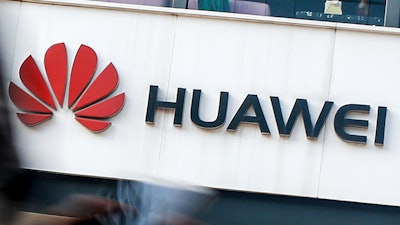 In this July 30, 2019, file photo a woman walks by a Huawei retail store in Beijing. Chinese tech giant Huawei has accused U.S. authorities of trying to coerce employees to gather information on the company and of trying to break into its information systems. The company, the target of U.S. accusations that it is a security threat, said Wednesday, Sept. 4, that American officials were using 'unscrupulous means' to disrupt its business.