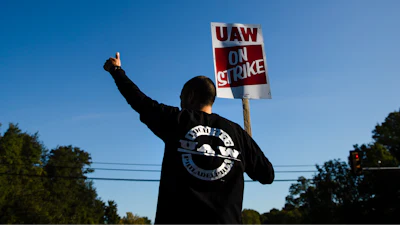 A worker gives the thumbs-up gesture to a passing motorist as he demonstratives outside a General Motors facility in Langhorne, Pa., Tuesday, Sept. 17, 2019. More than 49,000 members of the United Auto Workers walked off General Motors factory floors or set up picket lines early Monday as contract talks with the company deteriorated into a strike.