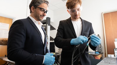 Gleb Yushin, a professor in Georgia Tech's School of Materials Science and Engineering and Kostiantyn Turcheniuk, research scientist in Yushin's lab, inspect a battery using a new cathode design that replaces expensive metals and traditional liquid electrolyte with lower cost transition metal fluorides and a solid polymer electrolyte. The research was funded by the U.S. Army.