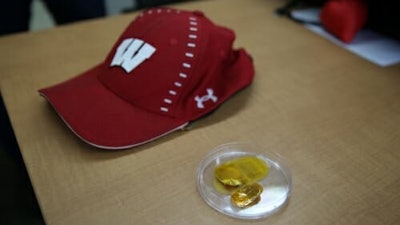 The device, right, is shown along with a baseball cap used to cover it.