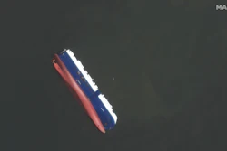 This Sept. 10, 2019 satellite photo provided by Maxar Technologies, shows the capsized cargo shop Golden Ray in Jekyll Island, Ga. A fire broke out aboard the ship early Sunday, listing it to the side and blocking the shipping channel. The Coast Guard and a salvage crew freed the four remaining Golden Ray crew members.