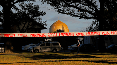 In this March 17, 2019, file photo a police officer stands guard in front of the Masjid Al Noor mosque in Christchurch, New Zealand, where one of two mass shootings occurred. Facebook will work with law enforcement organizations to train its machine learning technology to recognize videos of violent events as part of a broader effort to crack down on extremism. The move comes after its artificial intelligence did not detect the first-person video of a terrorist attack on the mosque in Christchurch.