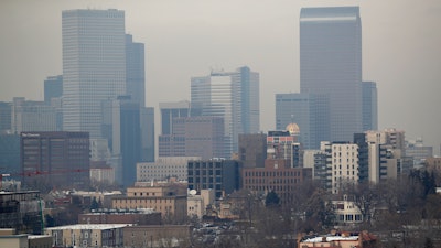 In this Jan. 21, 2003, file photograph, vehicles head inbound on South Broadway as polluted air obscures the view of the skyline of Denver from the south suburb of Englewood, Colo. The U.S. Environmental Protection Agency held a hearing Friday, Sept. 6, 2019, to discuss a plan to lower the ozone status of Denver and eight other northern Colorado counties from 'moderate' to 'serious,' a move that would force the state to clean the air but which businesses object to becuse of potential additional regulations.