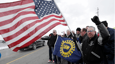 Mark Franko, 28-year General Motors employee, holds an American flag as employees gather outside the plant, Wednesday, March 6, 2019, in Lordstown, Ohio.