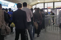 Uighurs wait in line at a face scan checkpoint in Turpan, Xinjiang in northwest China on April 11, 2018.