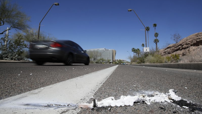 A vehicle goes by the scene of a fatality, where a pedestrian was stuck by an Uber vehicle in autonomous mode, in Tempe, Ariz., March 19, 2018.