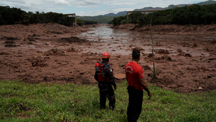 Civil firefighters survey a destroyed rail bridge two days after a dam collapse in Brumadinho, Brazil, Jan. 27, 2019.