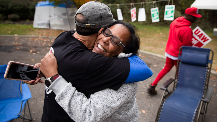 Picketing United Auto Workers Richard Rivera, left, and Robin Pinkney react to news of a tentative contract agreement with General Motors, in Langhorne, Pa., Wednesday, Oct. 16, 2019. Bargainers for General Motors and the United Auto Workers reached a tentative contract deal on Wednesday that could end a monthlong strike that brought the company's U.S. factories to a standstill.