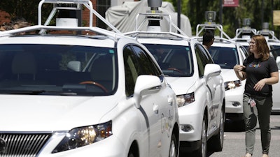 This May 13, 2014, file photo shows a row of self-driving Lexus cars at a Google event in Mountain View, Calif.