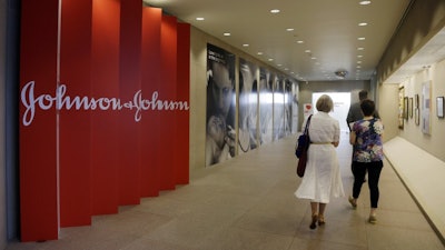 In this July 30, 2013, file photo, people walk along a corridor at the headquarters of Johnson & Johnson in New Brunswick, N.J.