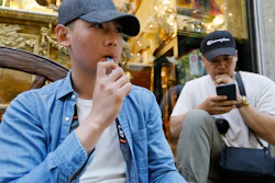 In this Monday, June 17, 2019, photo, Joshua Ni, 24, and Fritz Ramirez, 23, vape from electronic cigarettes in San Francisco.