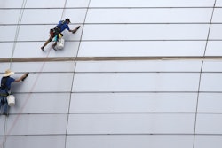 In this July 31, 2019, file photo, workers clean the outside facade of State Farm Stadium in Glendale, Ariz