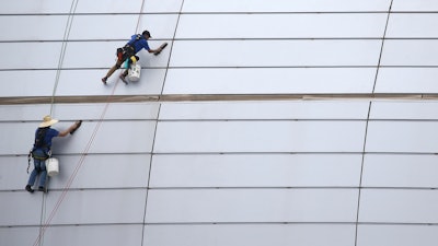 In this July 31, 2019, file photo, workers clean the outside facade of State Farm Stadium in Glendale, Ariz