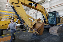 In this Sept. 18, 2019, photo, a Puckett Machinery Company technician walks past a new heavy duty Caterpillar excavator that awaits modification in Flowood, Miss.