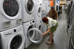 In this Sept. 23, 2019, photo, Maria Alvarez, front, and her husband Guillermo Alvarez examine washers and dryers at a Home Depot in Boston.