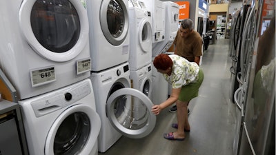 In this Sept. 23, 2019, photo, Maria Alvarez, front, and her husband Guillermo Alvarez examine washers and dryers at a Home Depot in Boston.
