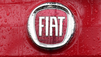 In this Jan. 2, 2014, file photo, a Fiat logo pictured on a car in Milan.