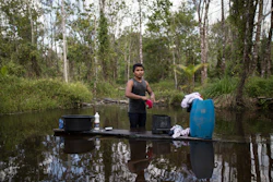 In this Sept. 2, 2019 photo, a young man washes his clothes in a pond in the viallge Ka 'a kyr, in Para state, Brazil.