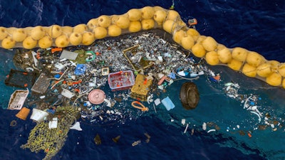 In this undated handout photo provided by The Ocean Clean Up, plastic is retained in front of an extended cork line in the Pacific Ocean. A Dutch inventor says that after a series of setbacks his system for catching plastic floating in the Pacific between California and Hawaii is now working. Boyan Slat, a university dropout who founded The Ocean Cleanup nonprofit, announced Wednesday, Oct. 2, 2019 that the floating boom is skimming up waste ranging in size from a discarded net and a car wheel complete with tire to chips of plastic measuring just 1 millimeter.