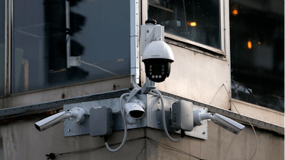 In this photo taken Sept. 25, 2019, high-tech video cameras hang from an office building in downtown Belgrade.