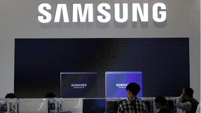Visitors near the logo of Samsung Electronics at a semiconductor exhibition in Seoul, Oct. 8, 2019.
