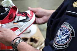 This undated photo shows an agent holding one of more than 14,800 pair of counterfeit Nike shoes, seized in a shipment arriving from China at the Los Angeles-Long Beach sports complex.