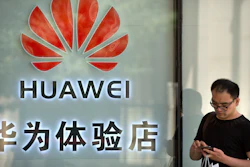 In this May 29, 2019, file photo, a man uses his smartphone outside of a shop selling Huawei products at a shopping mall in Beijing.