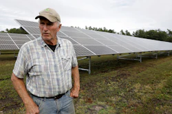 In this Oct. 2, 2019, photo, Dick Ward stands near a solar array in a cranberry bog on his farm in Carver, Mass.