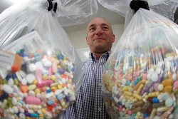 In this Sept. 11, 2019, file photo, narcotics detective Ben Hill of the Barberton Police Department shows two bags of medications stored in their headquarters.