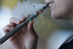In this Friday, Oct. 4, 2019, file photo, a woman using an electronic cigarette exhales in Mayfield Heights, Ohio.