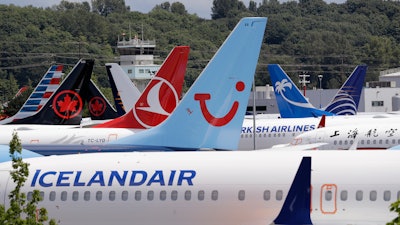 In this June 27, 2019, file photo, dozens of grounded Boeing 737 Max airplanes crowd a parking area adjacent to Boeing Field in Seattle.