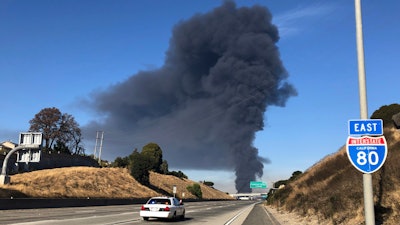Interstate 80 is closed as a fire at an oil storage facility burns in the background Tuesday, Oct. 15, 2019, in Rodeo, Calif.