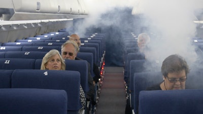FAA employees participate in a demonstration of an airline cabin filling with smoke in a simulator at the FAA Civil Aerospace Medical Institute in the Mike Monroney Aeronautical Center, Oklahoma City, Oct. 17, 2019.
