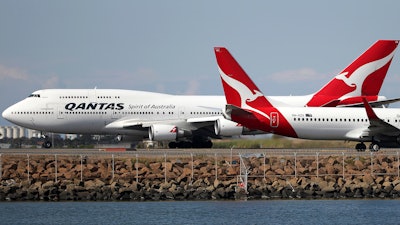 In this Aug. 20, 2015, file photo, two Qantas planes taxi on the runway at Sydney Airport.