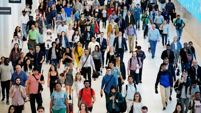 In this June 21, 2019, file photo, commuters walk through a corridor in the World Trade Center Transportation Hub in New York.