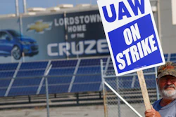 In this Sept. 16, 2019, file photo, a picketer carries sign at one of the gates outside the closed General Motors automobile assembly plant in Lordstown, Ohio.