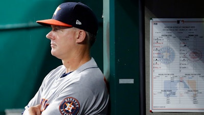 In this June 17, 2019, file photo, Houston Astros manager AJ Hinch looks on from the dugout in the fifth inning of a baseball game against the Reds in Cincinnati.